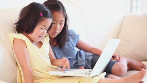 two girls watching something on a laptop