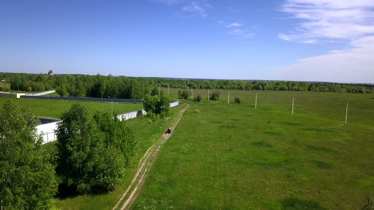 bicicleta quad en un camino de tierra a través de un paisaje rural