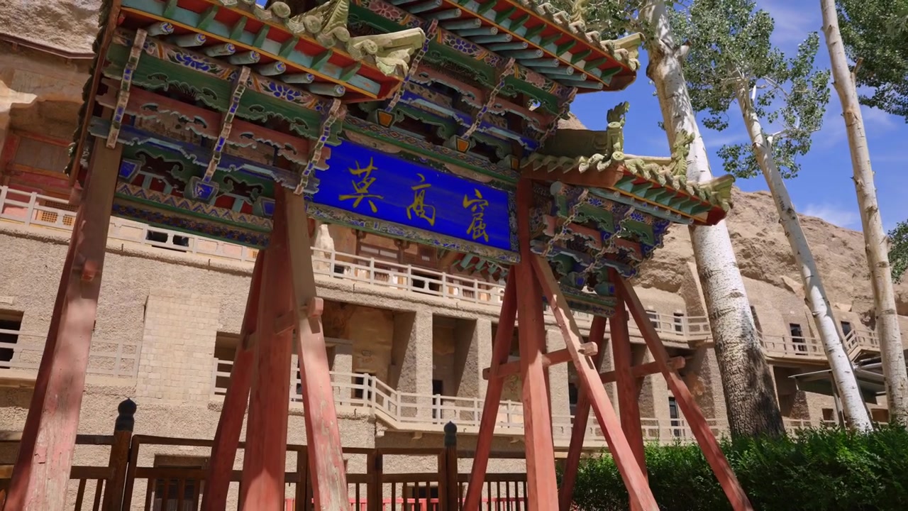 Grotte di Mogao: Grotte rupestri esterne, antico sito del patrimonio buddista a Dunhuang, Gansu, Cina. Punto di riferimento culturale della Via della Seta, con l'arco tradizionale cinese e le Grotte di Buddha scavate nella roccia.