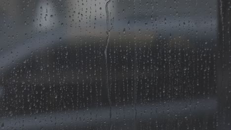 gotas de lluvia reales deslizándose en el vidrio de la ventana, c-log color crudo, 4k
