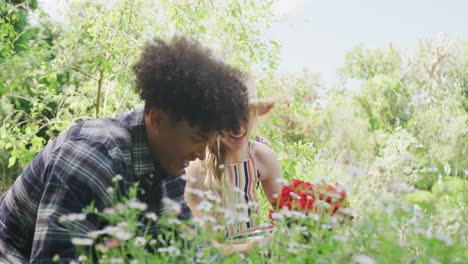 happy diverse couple working in garden on sunny day