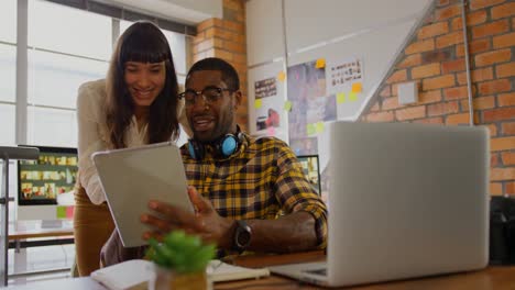 graphic designers working together on digital tablet at desk in office 4k