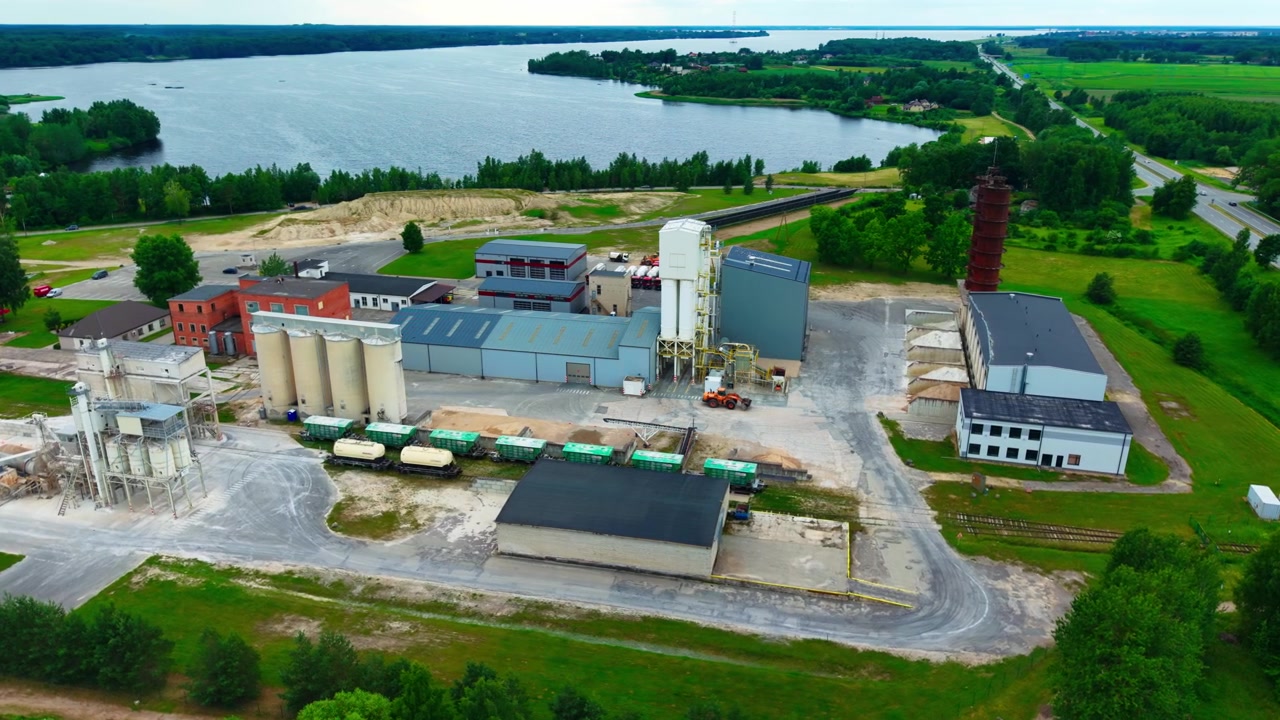 High angle view, aggregate production facility with storage silos beside river