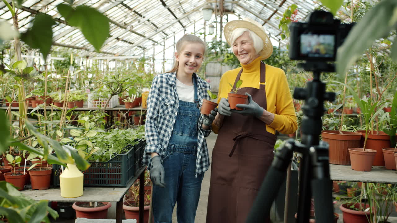 Grandmother and Granddaughter Vlogging About Gardening in a Greenhouse