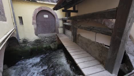 puerta frontal hacia la casa tradicional de madera con puente de madera para cruzar la corriente del río