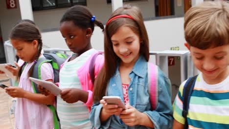 group of school kids using digital tablet and mobile phone