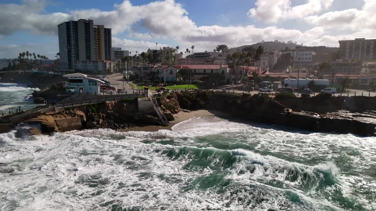 Aerial clip showing bright reef patterns and whitewater along the iconic La Jolla San Diego Ca coastline near the Children's pool