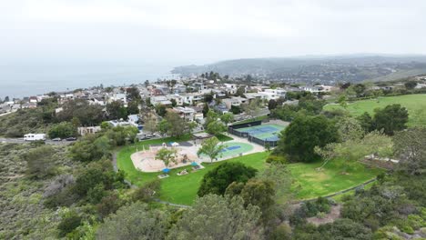 Pequeño-Parque-De-Diversión-En-Un-Barrio-Costero-De-Aliso-Beach,-California,-Panorámica-Aérea-De-Camiones-A-60-Fps.