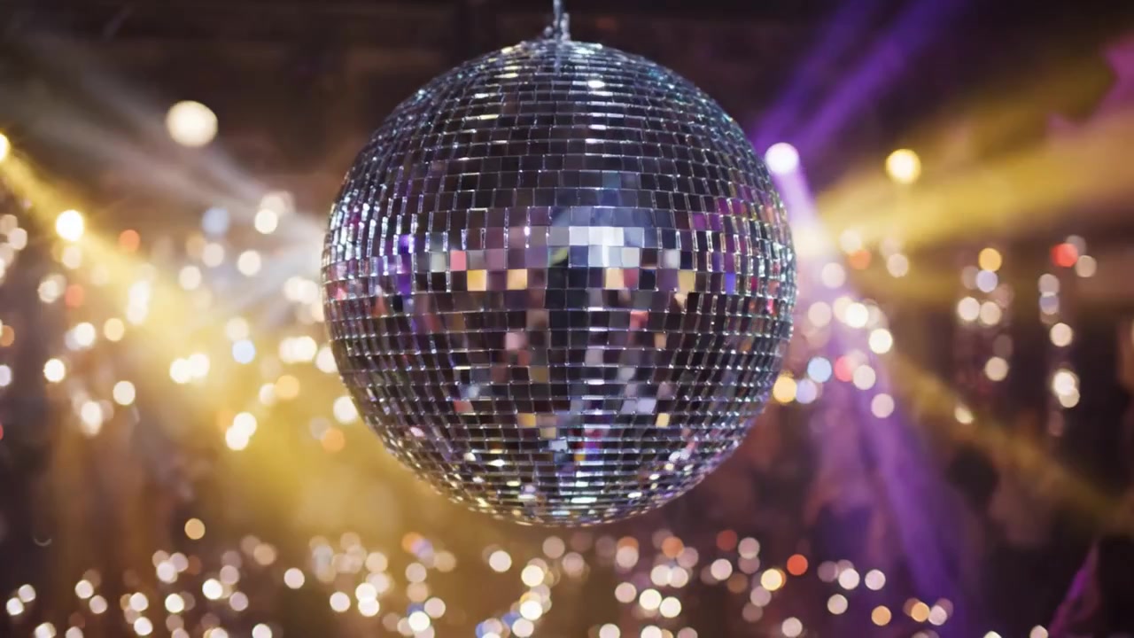 Riflessi Accattivanti di una Palla da Discoteca a un Evento Festivo, Circondata da Luci Colorate e Partecipanti Entusiasti che Creano un'Atmosfera Vibrante