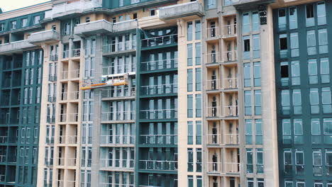 construction of a modern building in the city. facade of multistorey apartment house with plastic windows in the city. building of a new architecture.