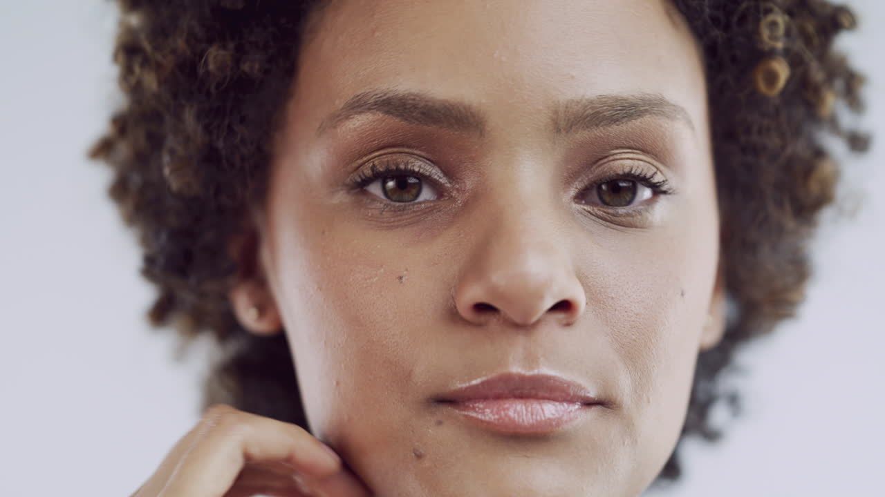 Close-up portrait of a woman with curly hair and makeup