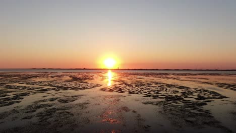 stunning orange sunset over tidal flat of north sea in germany