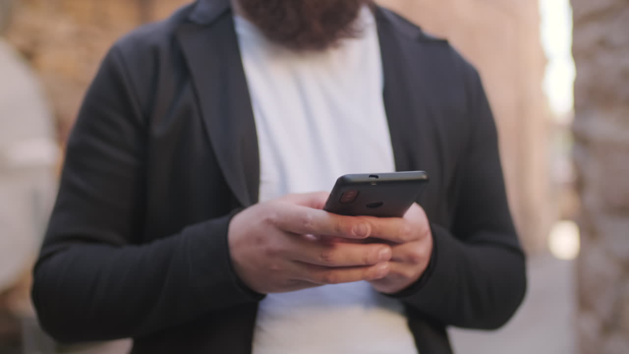 Unrecognizable Man Texting on Phone Outside
