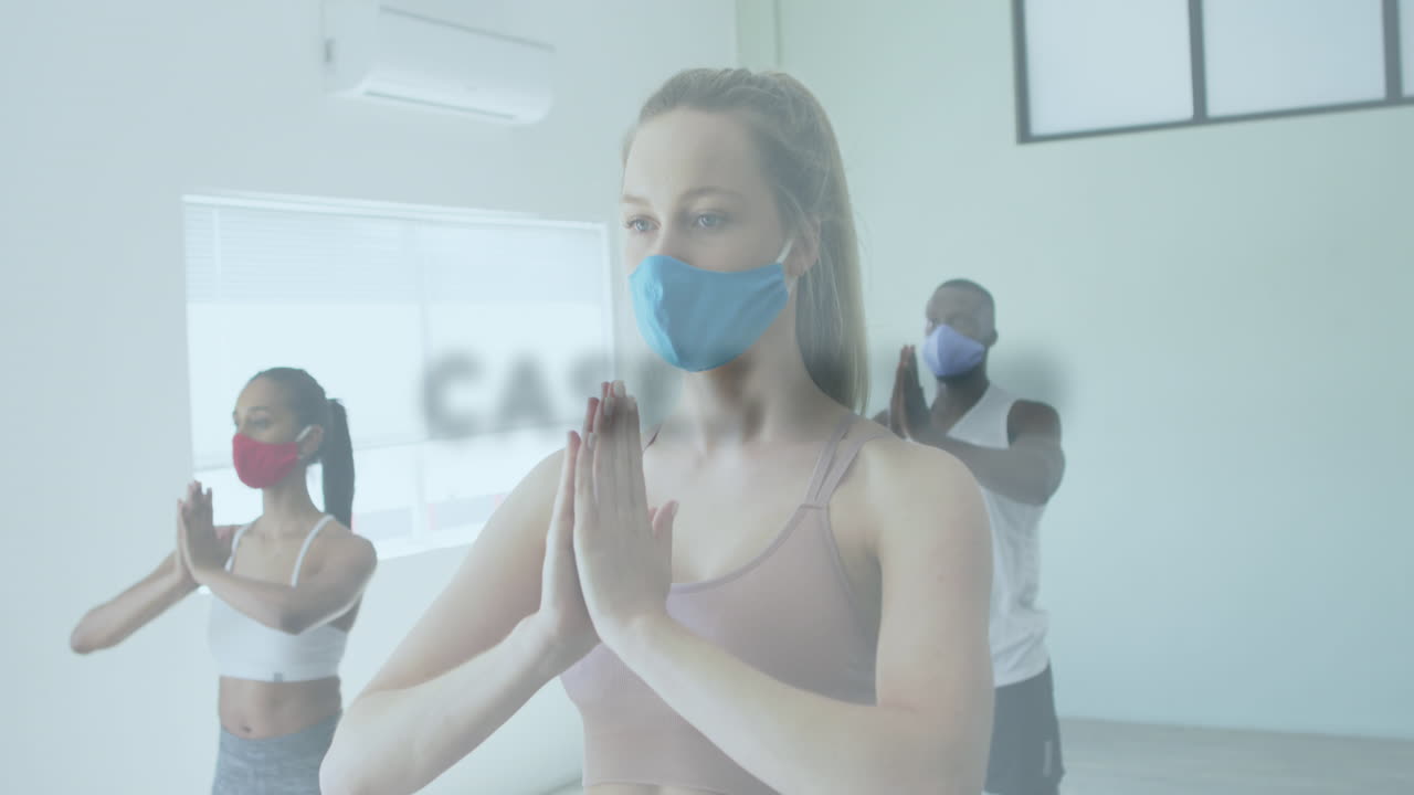 animación de palabras que parpadean sobre un grupo diverso que usa máscaras faciales practicando yoga