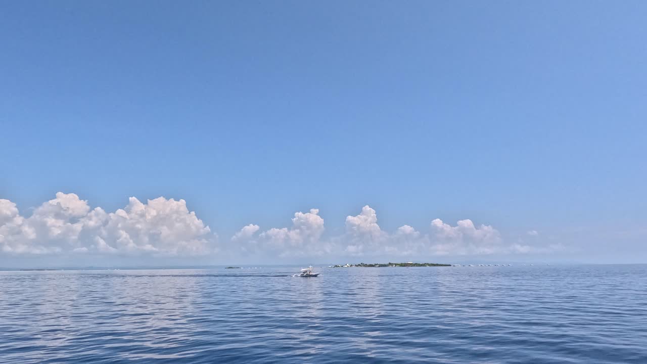 Riding a Bangka Boat with Gilutongan Island in the Distance during an Island Hopping Tour in Mactan, Cebu, Philippines