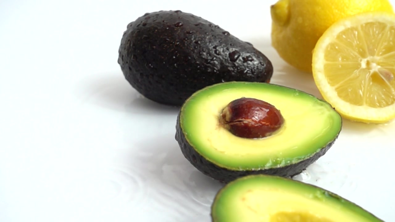 Avocado fresco e maturo e limone succoso. Movimento lento