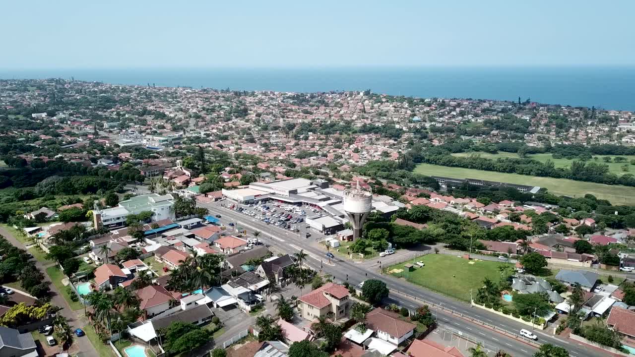 imágenes aéreas de un avión no tripulado volando sobre casas residenciales con vistas a una autopista concurrida con tráfico en movimiento en un suburbio de yellow wood park durban