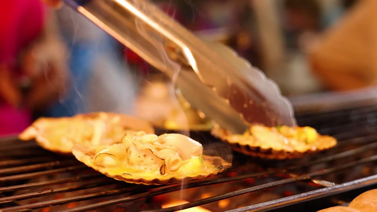 Scallops grilled over open flame with tongs, vibrant street food scene, warm lighting, shallow focus