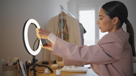 influencer girl rotating cellphone home closeup. blogger changing phone position