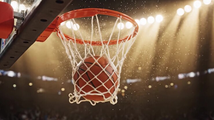 Un Drammatico Primo Piano di un Canestro da Basket in Movimento con una Palla Che Si Avvicina alla Rete Tra le Luci Brillanti e l'Eccitazione della Partita, Catturando l'Essenza della Competizione