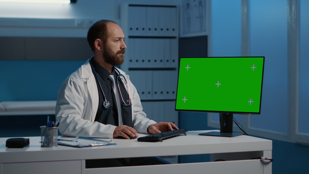Doctor working on computer with green screen