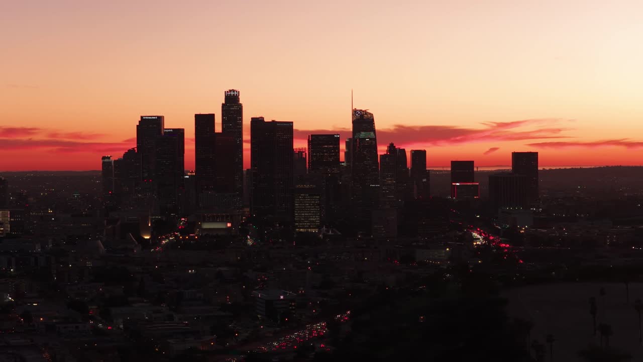 Toma aérea panorámica con dolly del tráfico en el centro de Los Ángeles durante la hora mágica en California del Sur. 4K