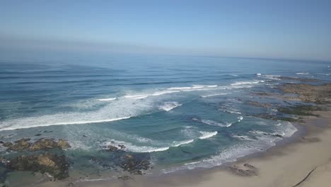 Aerial-Top-View-Of-Sea-Waves-Reaching-Beach-Shore,-Drone-Footage