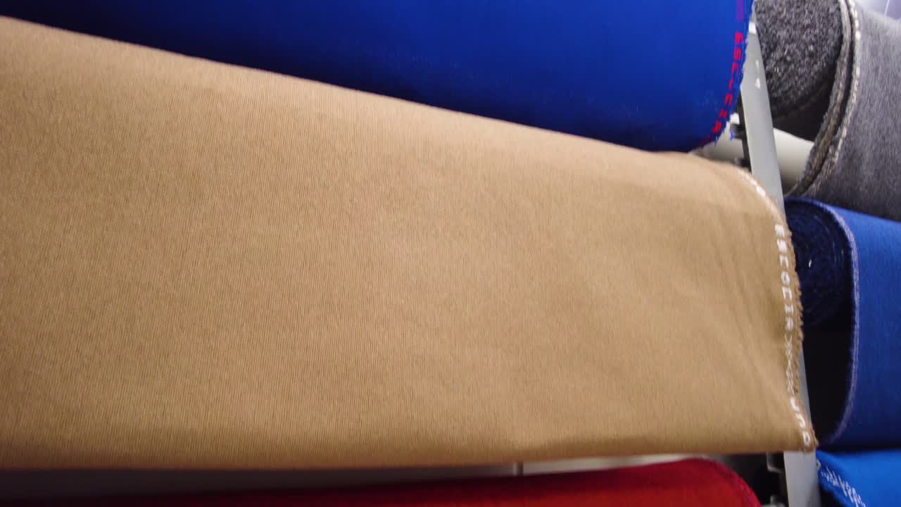 stands with rolls of fabric In a textile shop