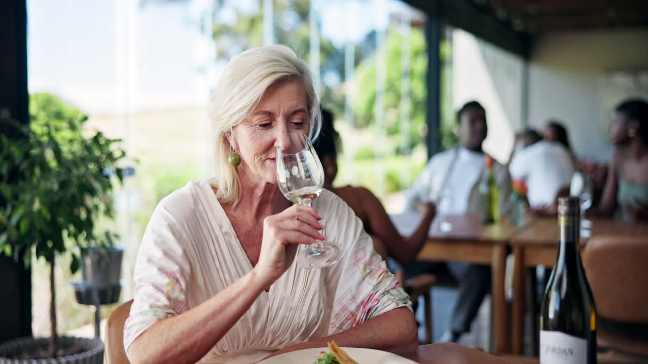 Elegant Senior Woman Enjoying White Wine at a Winery Restaurant