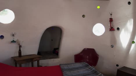 eco-friendly earthen home interior showcasing a bedroom with earthy decor and cozy furniture, pullback over bed showcasing ceiling support beams
