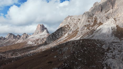 rugged mountain landscape at passo giau with rocky peaks under a bright blue sky and light clouds