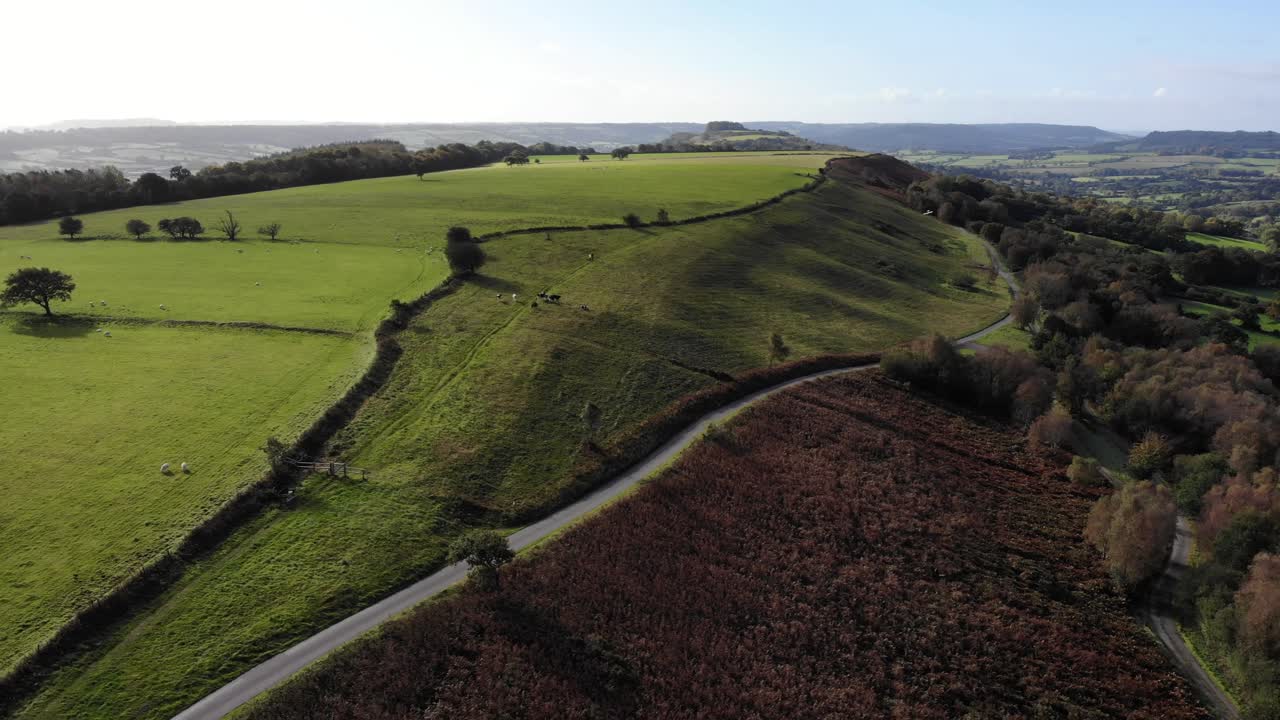 toma aérea hacia atrás que muestra la hermosa colina hartridge en el este de devon con la campiña inglesa más allá