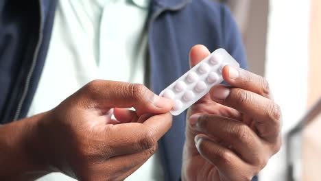person holding a blister pack of pills