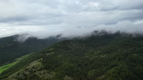 Wilde-Berge-Mit-Kiefernwäldern,-Die-Nach-Dem-Regen-In-Morgennebel-Gehüllt-Sind-Und-Eine-Heitere-Und-Mystische-Landschaft-Schaffen