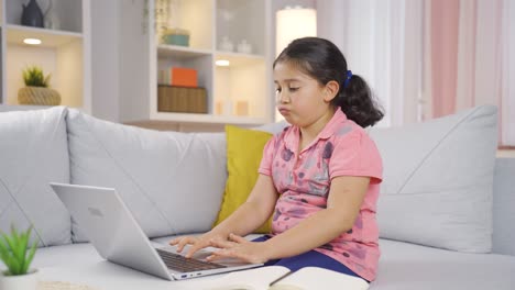 niña cerrando el portátil con expresión de enojo.