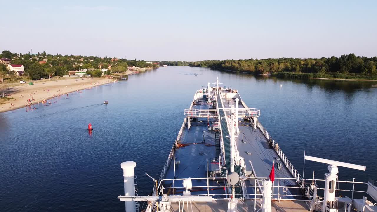 해변 과 도시 풍경 을 가진 강 에 있는 화물선