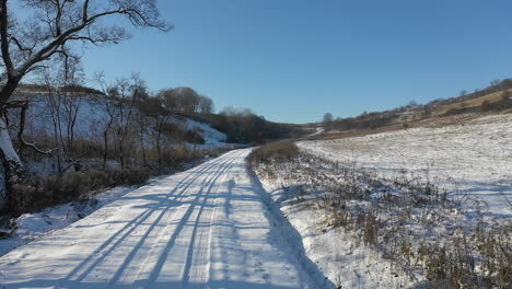 calm road coverd in snow passing through landscape in winter