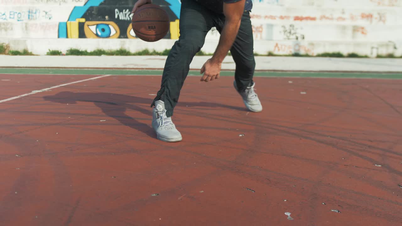 baloncesto regateando en tiempo real entre las piernas en la cancha al aire libre