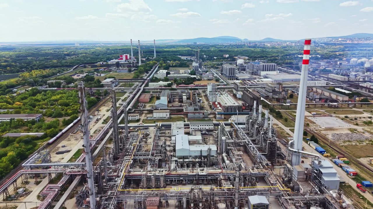 Vista aerea di una zona industriale con fabbriche e attrezzature situate in un paesaggio verde in una giornata di sole.