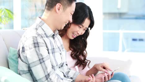 スマートフォンを一緒に使っている幸せなカップル