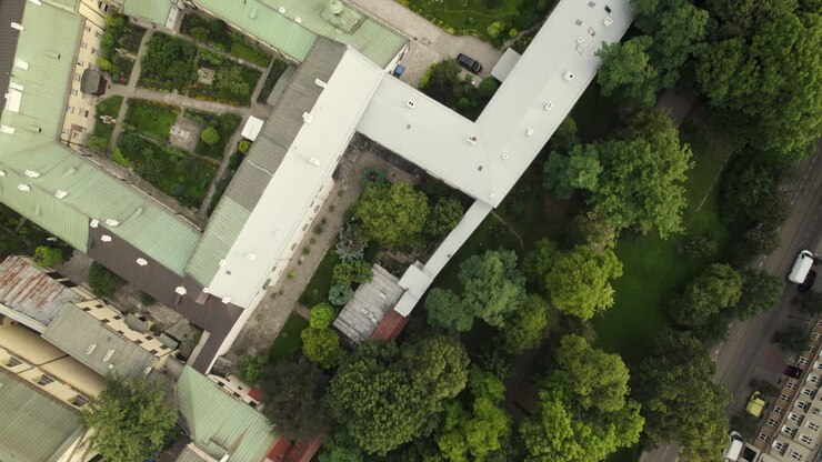 Toma aérea cenital de la Iglesia de San Pedro y San Pablo en Cracovia, rodeada de árboles