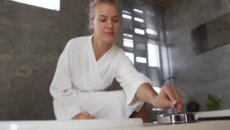 mujer caucásica preparando el baño en el hotel