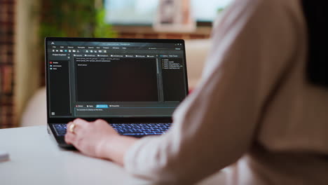 asian female programmer works on coding software in a home office setup