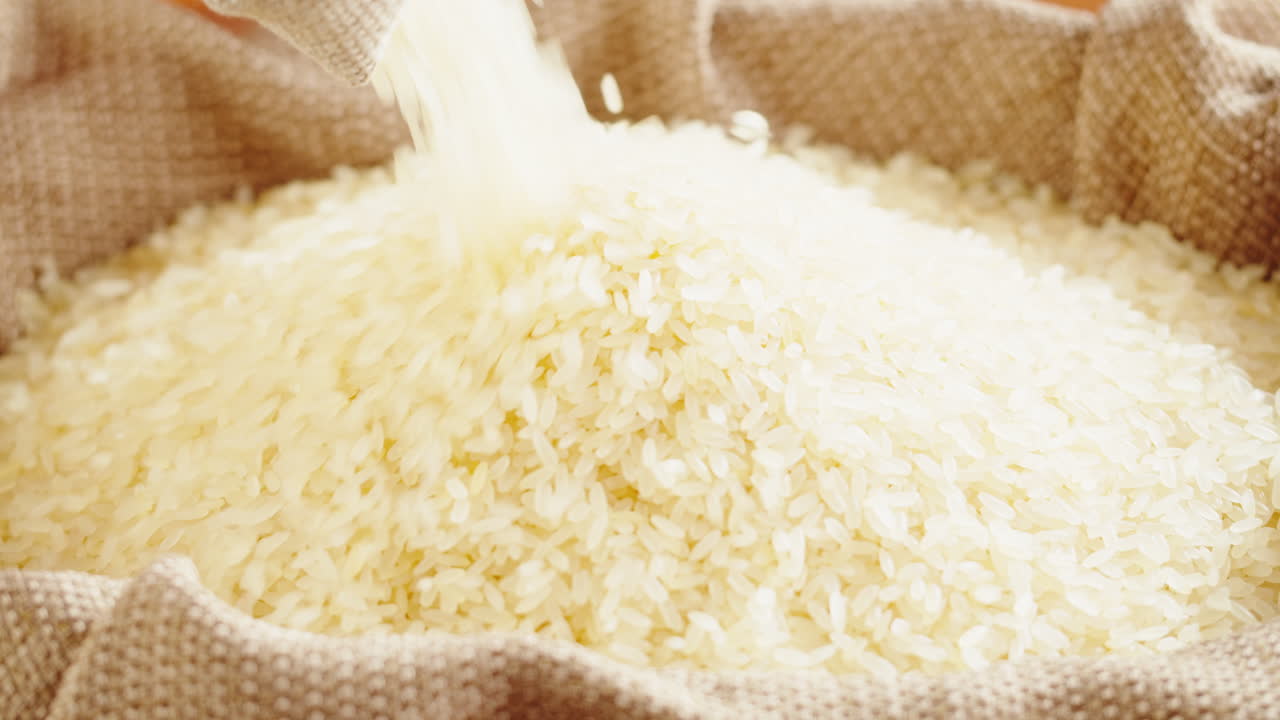 Rice Grains Being Poured into a Burlap Sack
