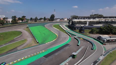 drone-view-of-race-track-circuit-in-Brazil,-cars,-people-gathered-and-asphalt