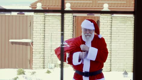 santa claus walk to the house with a bag of presents