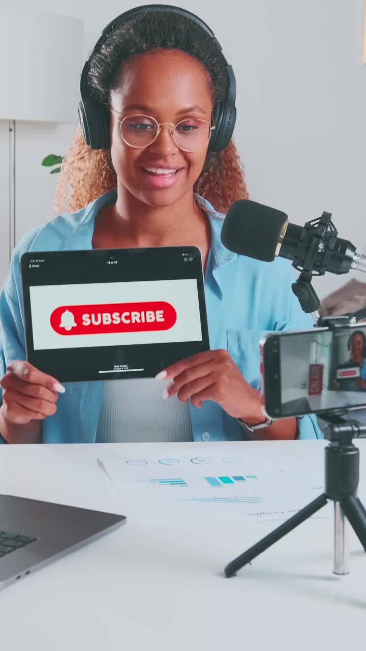 Young african american woman blogger shows tablet with inscription subscribe