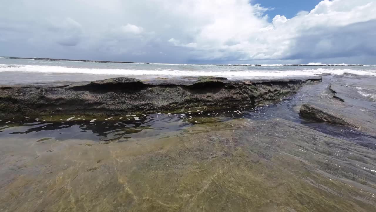 hermoso paisaje de pequeñas olas que se estrellan sobre grandes rocas de la playa de tibau do sul cerca de pipa, brasil en río grande do norte durante un día nublado de verano