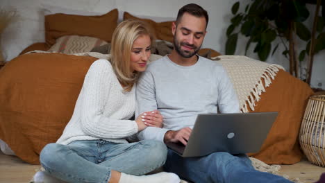 Una-Pareja-Encantadora-Haciendo-Una-Videollamada-Con-Su-Familia-Y-Mostrando-Un-Regalo-De-Navidad