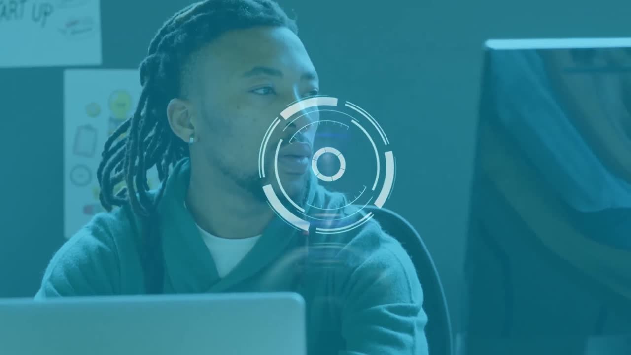 Animation of scanning icon moving over african american businessman with dreadlocks using laptop